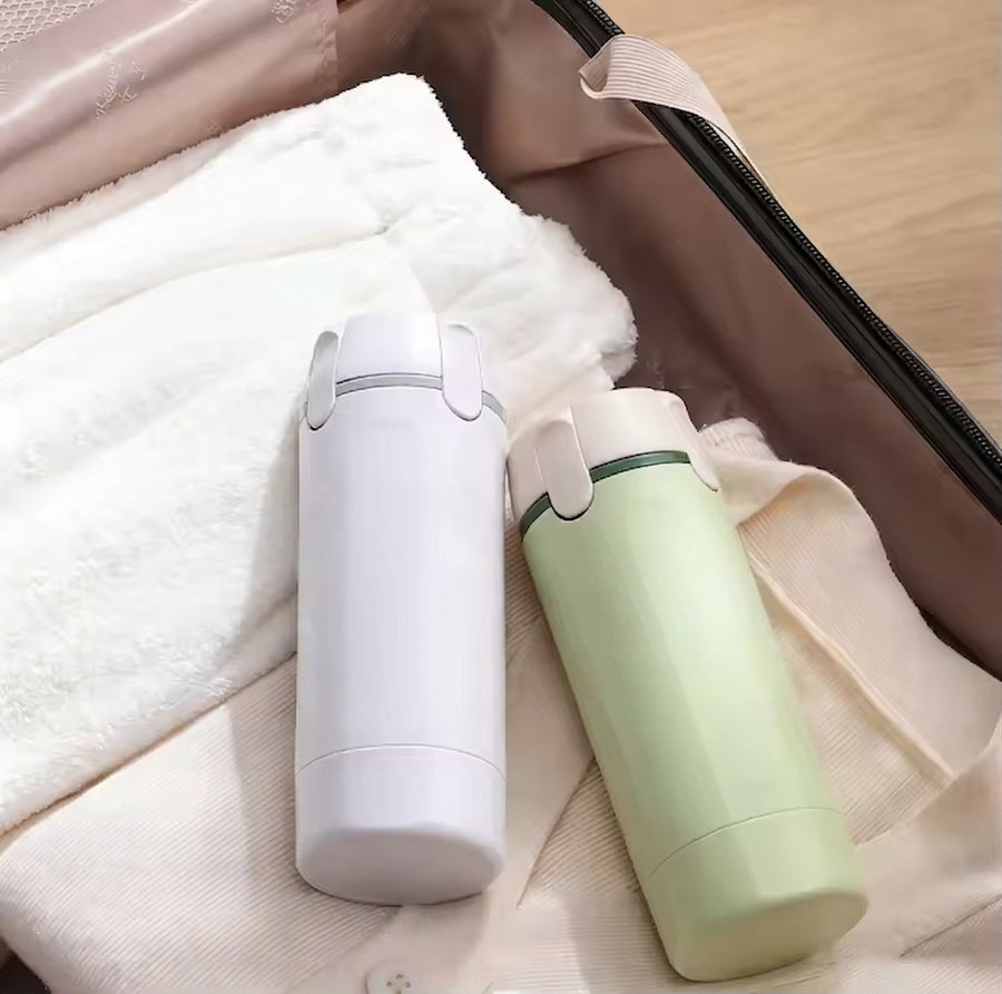 4-in-1 travel toiletry bottle packed in a carry-on suitcase with folded clothes
